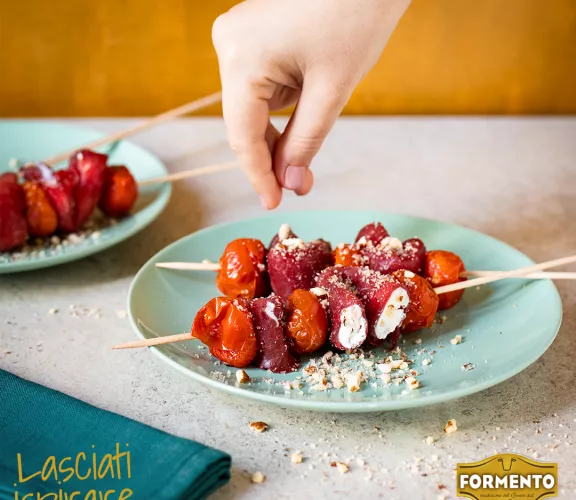 Carpaccio con robiola, pomodorini confit e granella di nocciole